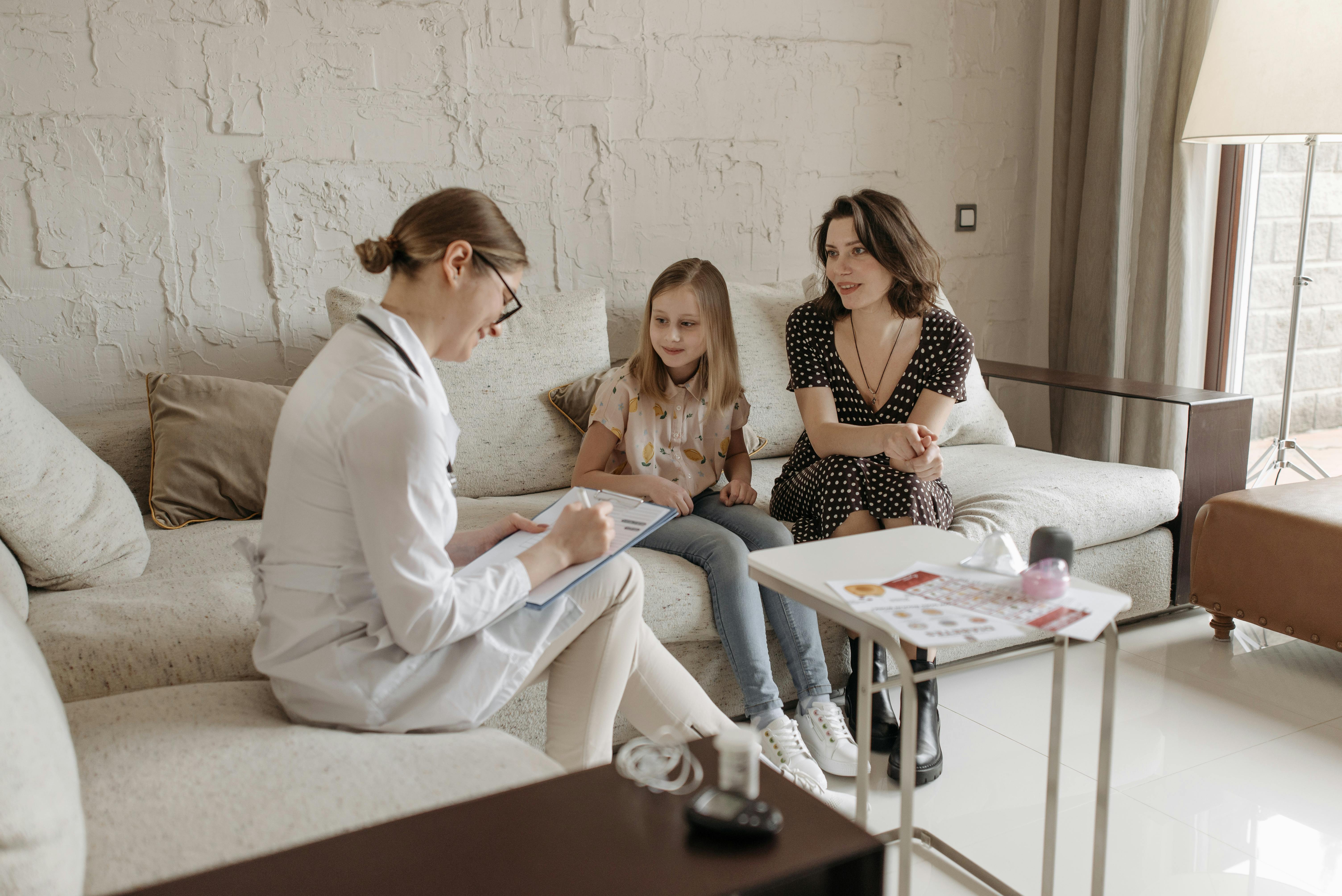 Clinician meeting with a caregiver and child during a consultation